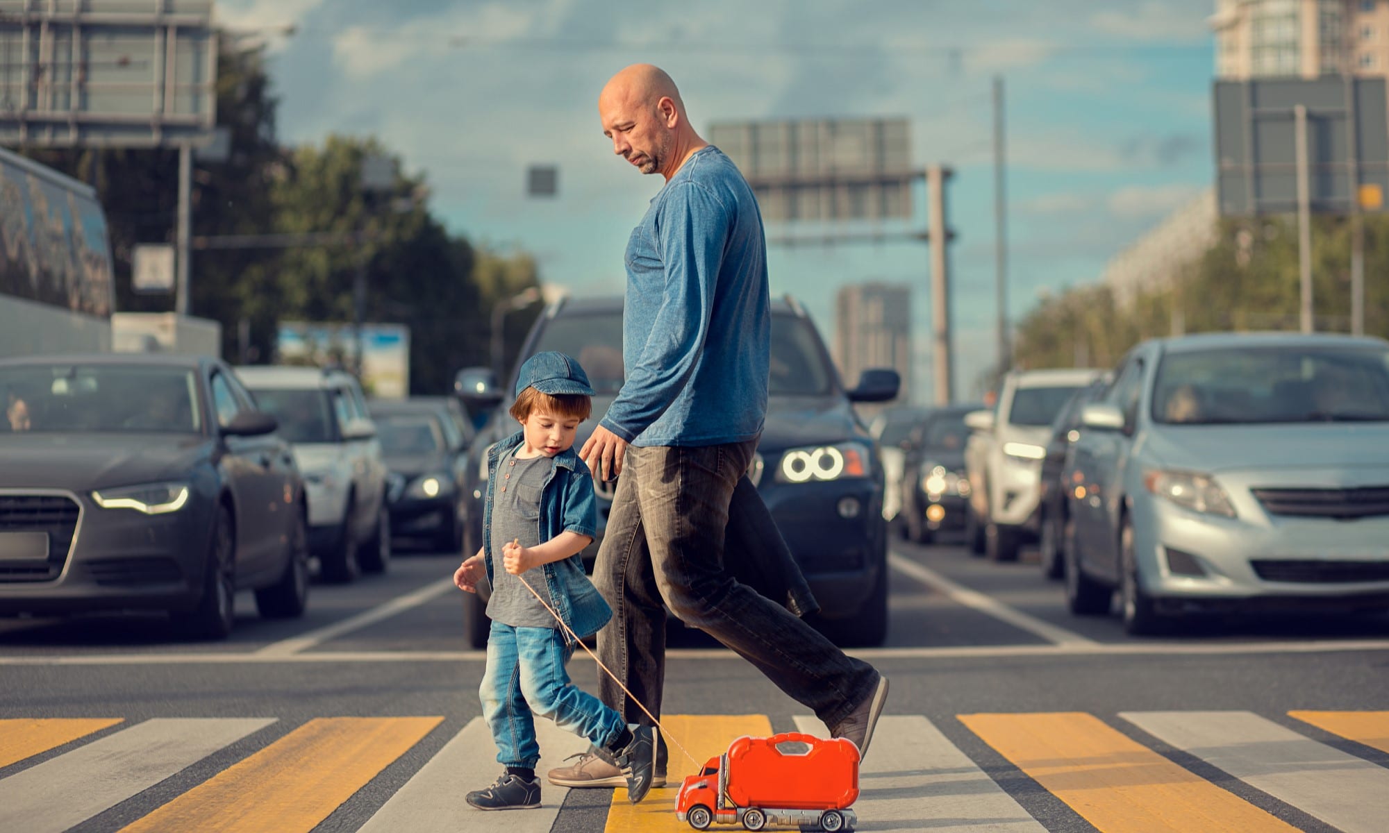 man and child crossing the street